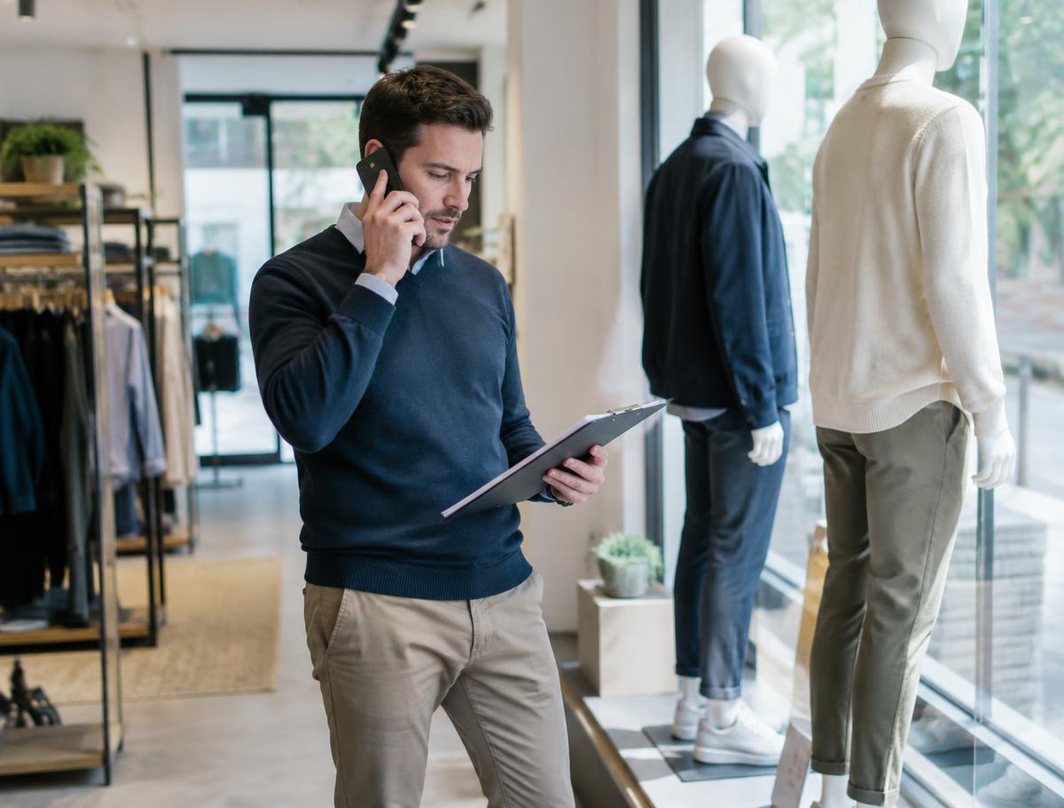 A store manager talking through the opening checklist beside a window display